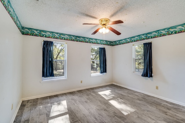 unfurnished room featuring ceiling fan, wood-type flooring, and a textured ceiling