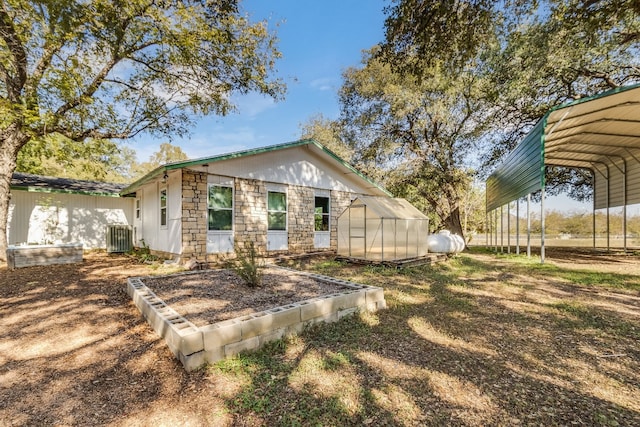 exterior space with an outbuilding, cooling unit, and a carport