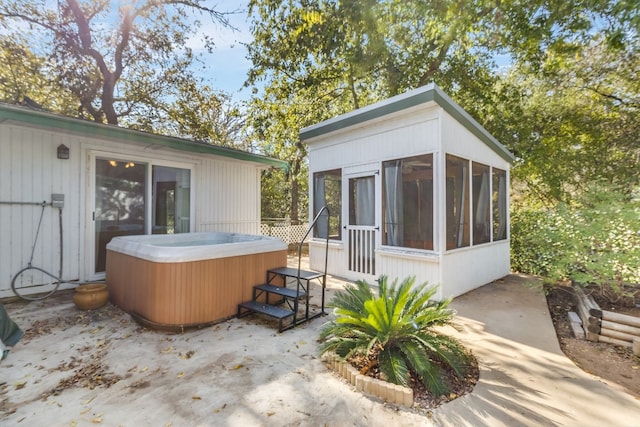 exterior space featuring a hot tub and a sunroom