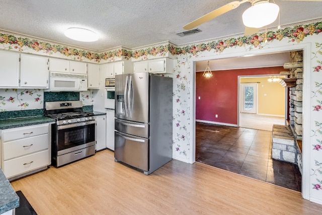 kitchen featuring white cabinetry, light hardwood / wood-style flooring, stainless steel appliances, and a textured ceiling