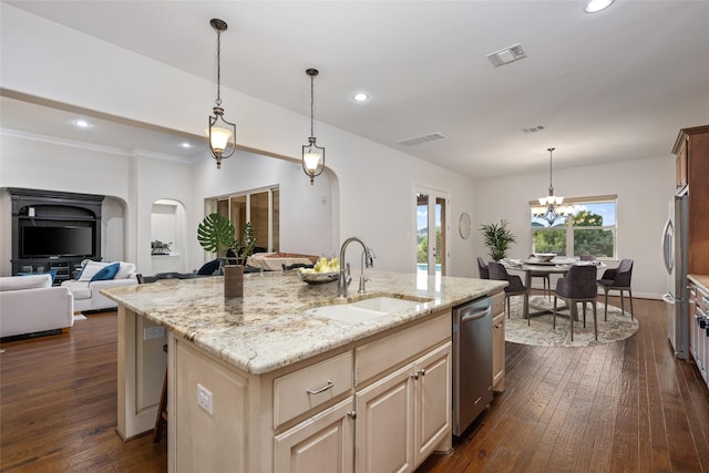 kitchen with light stone countertops, dark hardwood / wood-style flooring, stainless steel appliances, sink, and a kitchen island with sink