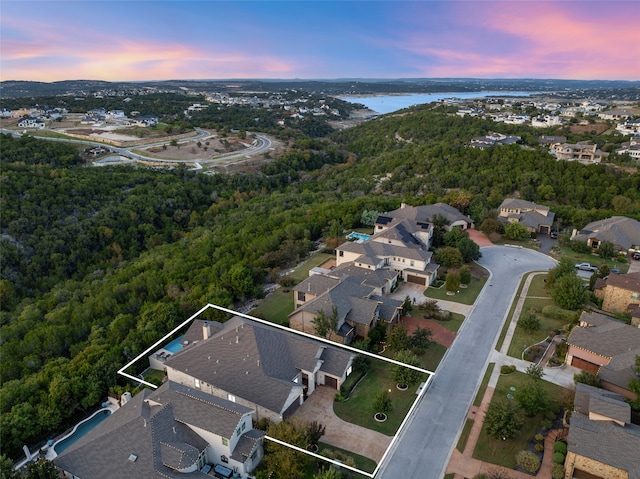 aerial view at dusk featuring a water view