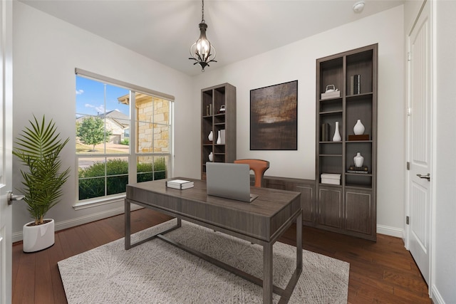 home office featuring dark hardwood / wood-style flooring and a notable chandelier