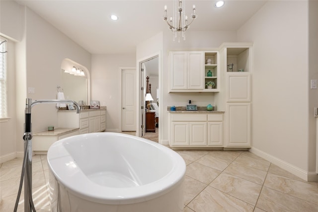 bathroom with vanity, a bathtub, and a notable chandelier