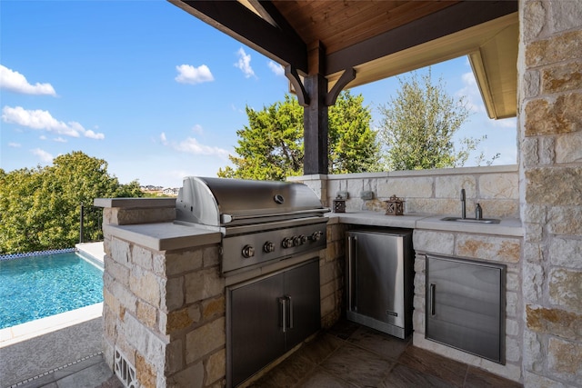 view of patio with an outdoor kitchen, area for grilling, and sink