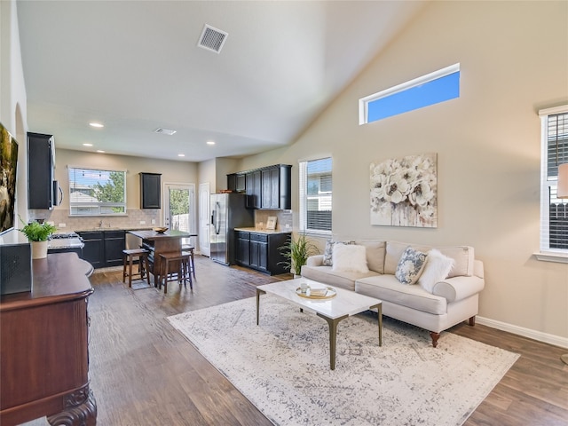 living room featuring dark hardwood / wood-style floors and high vaulted ceiling