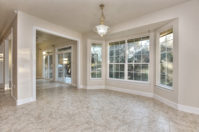 spare room with a chandelier and plenty of natural light