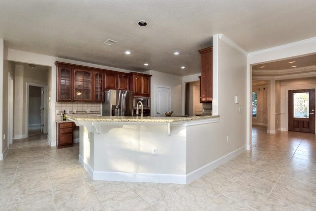 kitchen with stainless steel fridge with ice dispenser, backsplash, kitchen peninsula, a kitchen bar, and ornamental molding