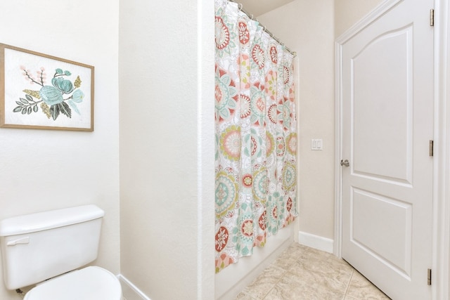 bathroom featuring toilet, tile patterned floors, and shower / tub combo with curtain