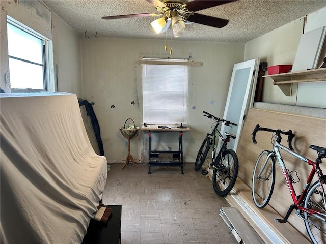 miscellaneous room featuring light wood-type flooring, a textured ceiling, and ceiling fan