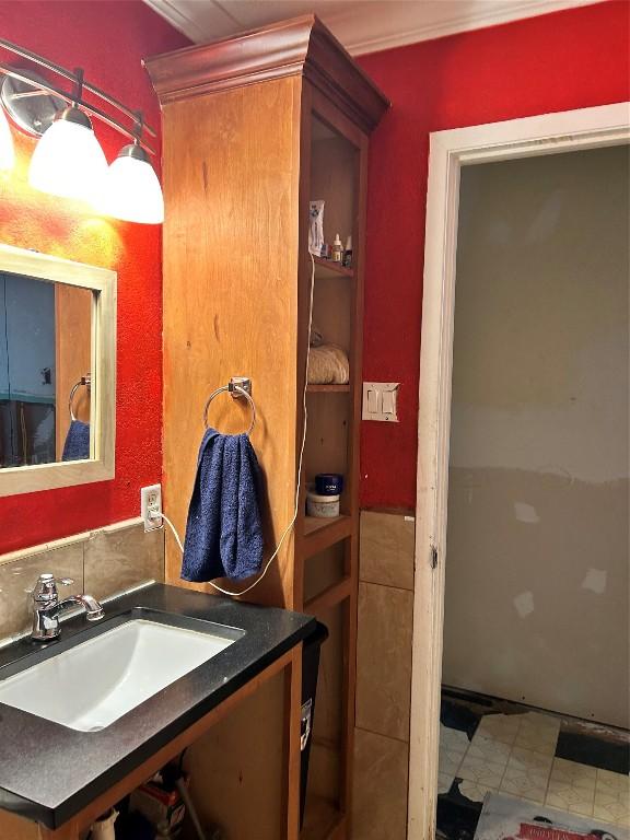 bathroom with tile patterned floors, vanity, and ornamental molding