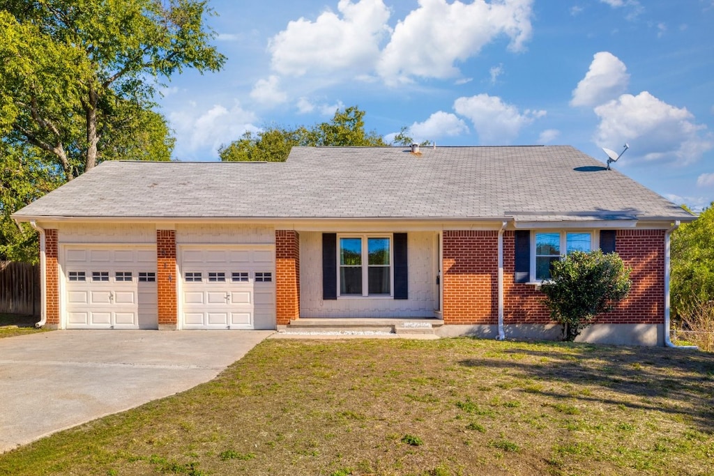 ranch-style house with a garage and a front lawn