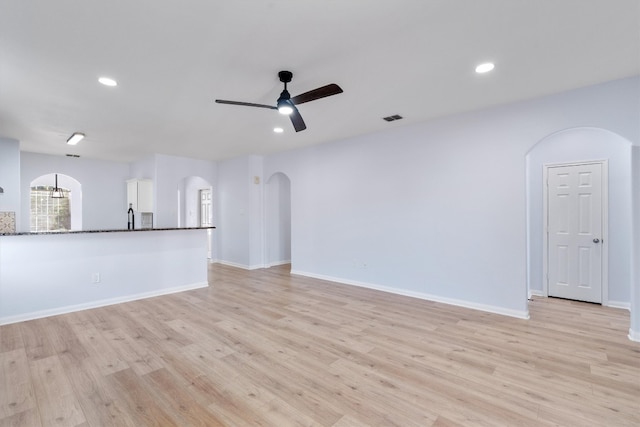 unfurnished living room featuring ceiling fan and light hardwood / wood-style floors