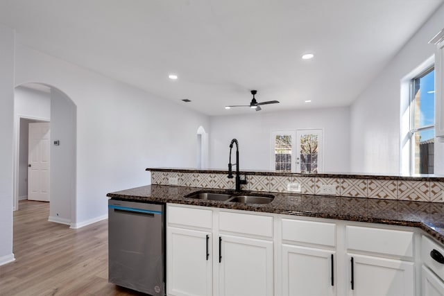 kitchen featuring dark stone counters, white cabinetry, and stainless steel dishwasher