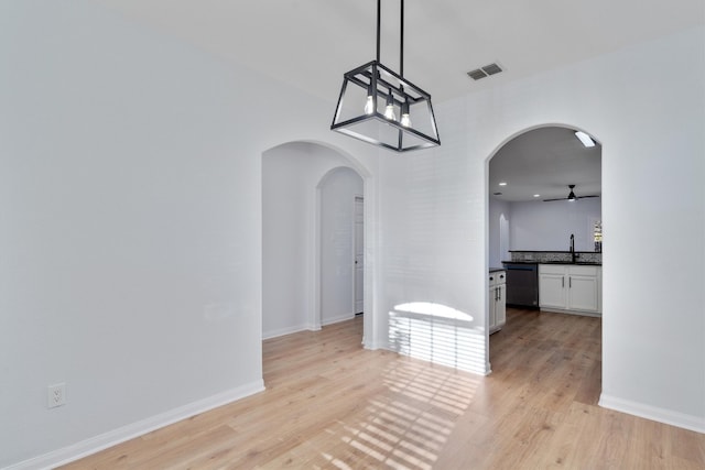 unfurnished dining area with ceiling fan, sink, and light hardwood / wood-style flooring