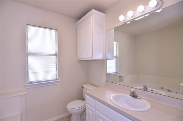 bathroom with tile patterned flooring, vanity, toilet, and a tub to relax in