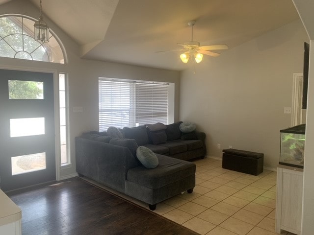 living room featuring ceiling fan, a healthy amount of sunlight, vaulted ceiling, and light wood-type flooring