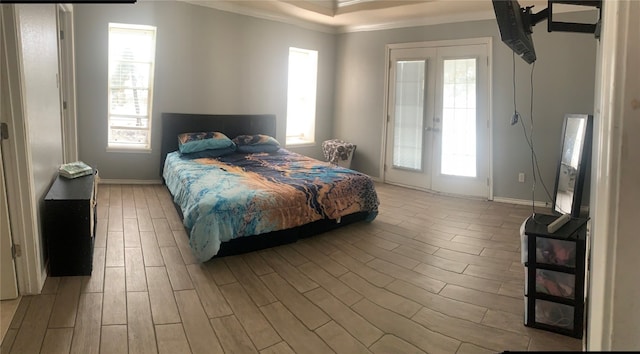 bedroom featuring french doors, light hardwood / wood-style flooring, and ornamental molding