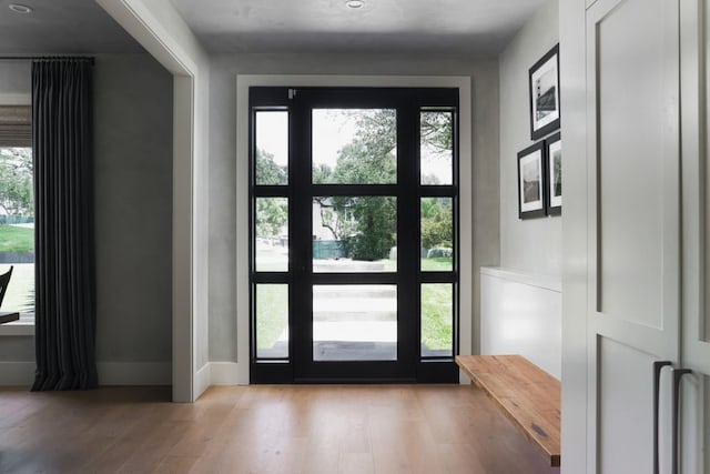 doorway to outside featuring a wealth of natural light and light hardwood / wood-style floors