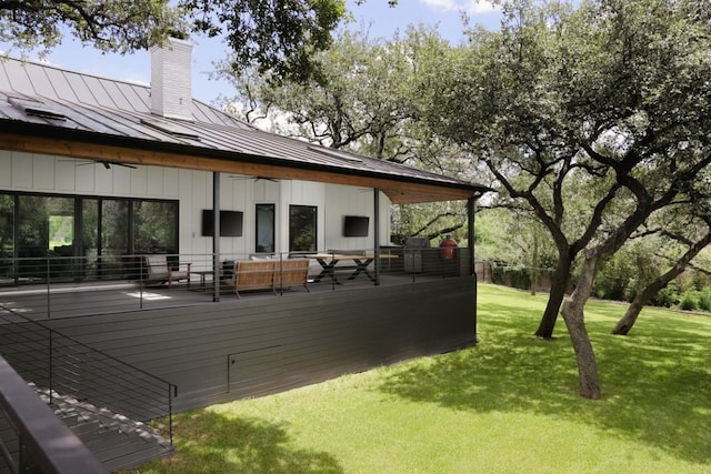 wooden terrace with outdoor lounge area, a yard, and ceiling fan