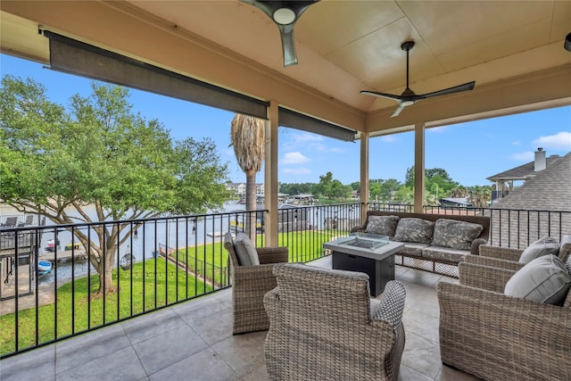 view of patio / terrace featuring a water view, an outdoor living space with a fire pit, and ceiling fan