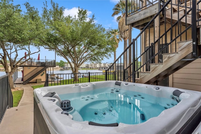 exterior space featuring a water view and a hot tub