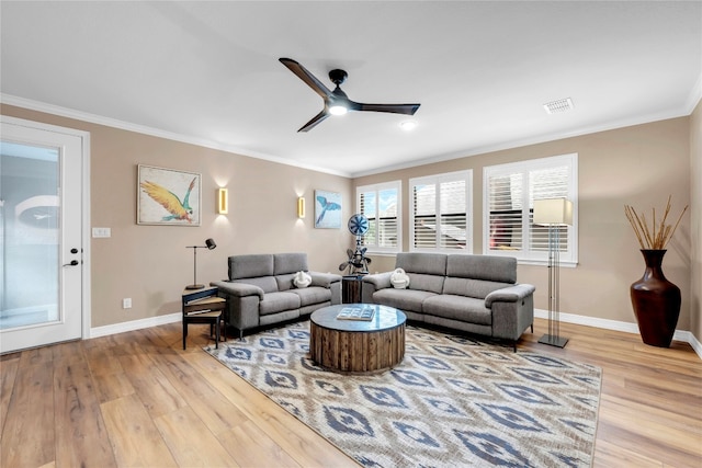 living room with light hardwood / wood-style floors, ceiling fan, and crown molding