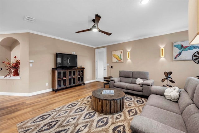 living room with hardwood / wood-style floors, ceiling fan, and ornamental molding