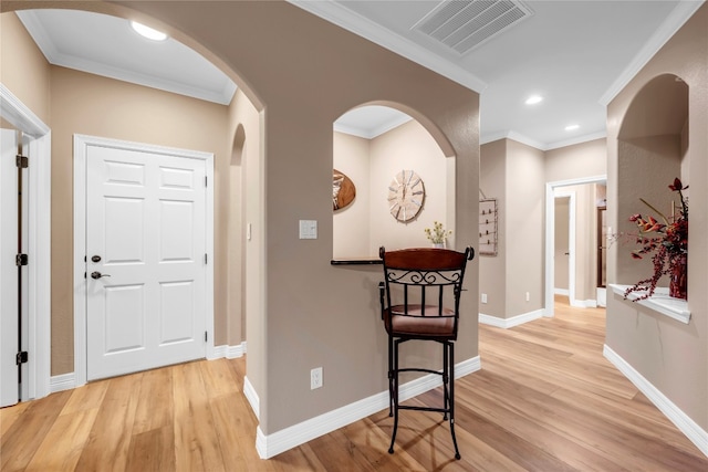 hallway featuring ornamental molding and light hardwood / wood-style flooring