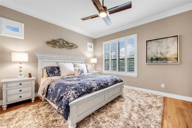 bedroom featuring light hardwood / wood-style flooring, ceiling fan, and crown molding