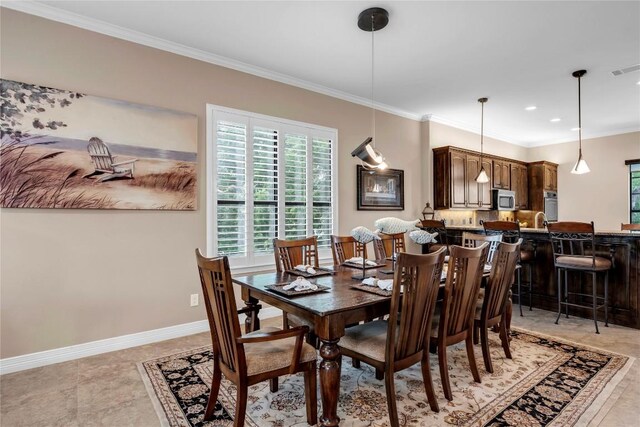 tiled dining room featuring crown molding