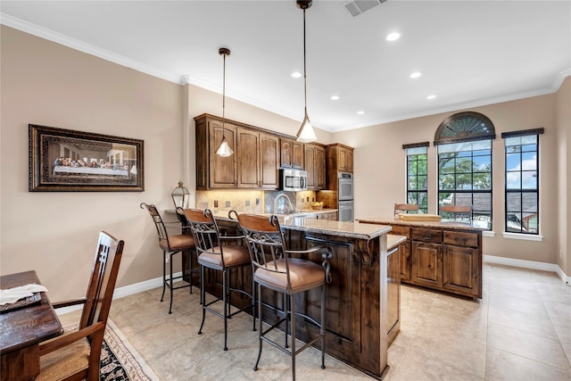 kitchen with tasteful backsplash, kitchen peninsula, crown molding, decorative light fixtures, and a breakfast bar