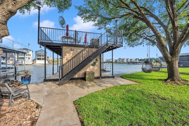 view of dock with a water view and a yard