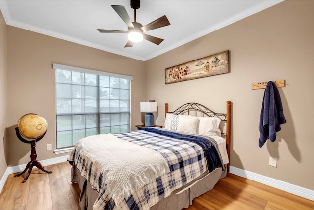 bedroom with hardwood / wood-style floors, ceiling fan, and multiple windows