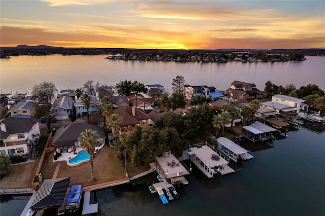 aerial view at dusk featuring a water view