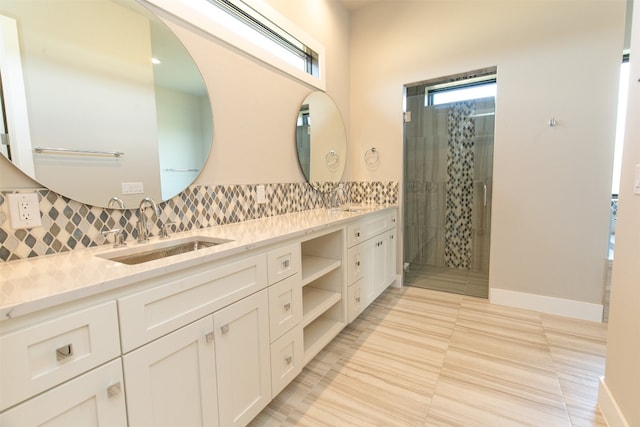 bathroom featuring tile patterned flooring, vanity, a shower with door, and tasteful backsplash