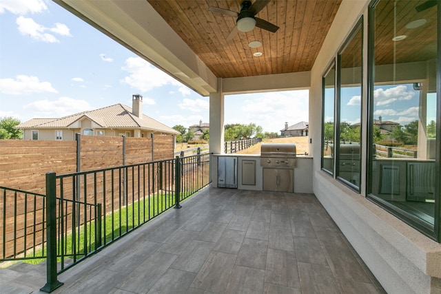 view of patio / terrace featuring ceiling fan, exterior kitchen, and a grill