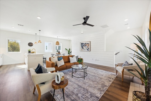 living room with ceiling fan, sink, and dark hardwood / wood-style floors