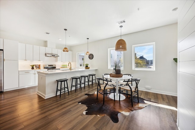 dining room with dark hardwood / wood-style floors and sink