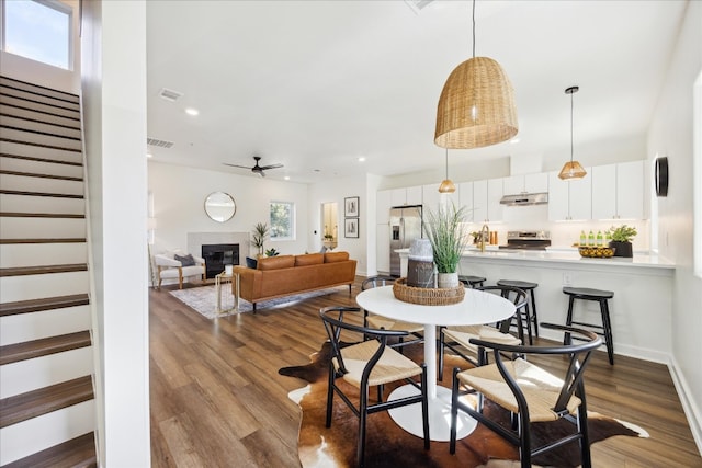 dining room featuring hardwood / wood-style floors, ceiling fan, and sink