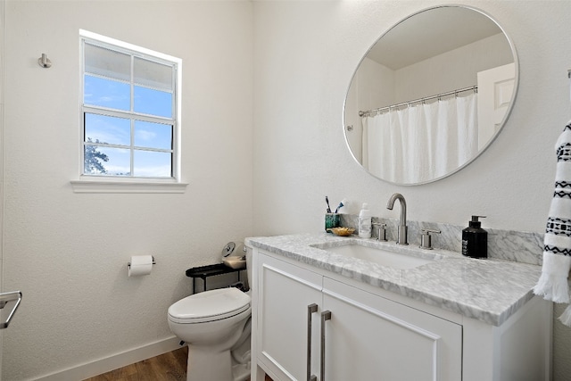 bathroom featuring vanity, hardwood / wood-style flooring, and toilet