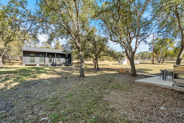 view of yard with a deck and a storage unit