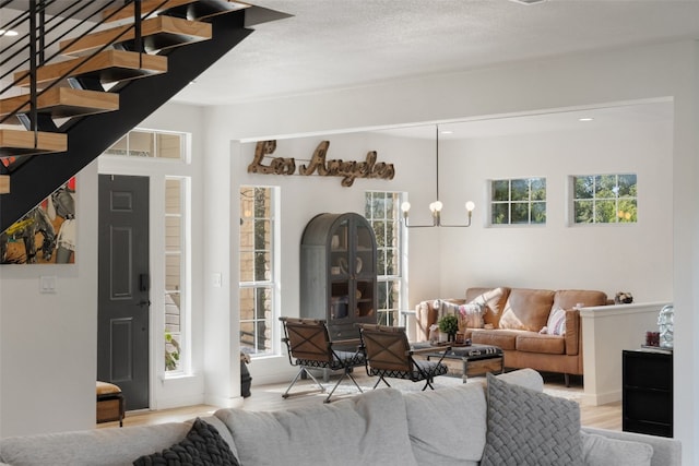 living room featuring plenty of natural light, an inviting chandelier, and light hardwood / wood-style flooring