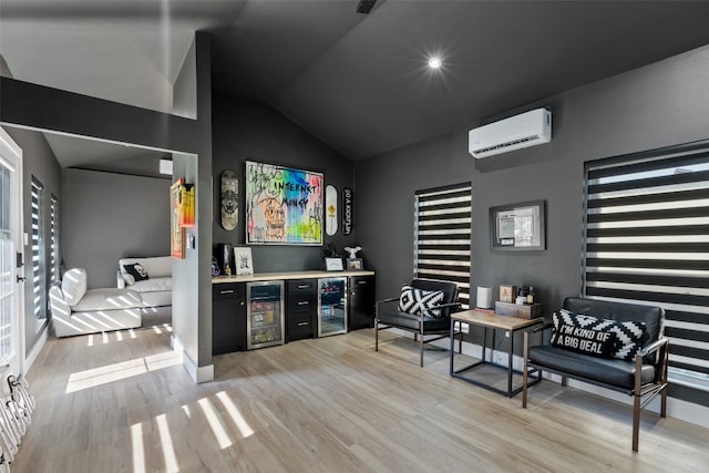 bar featuring vaulted ceiling, light wood-type flooring, beverage cooler, and a wall mounted AC