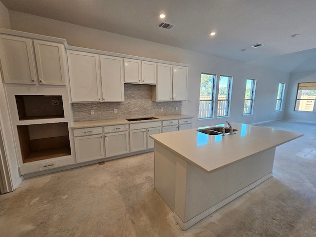 kitchen with white cabinets, sink, an island with sink, and a wealth of natural light