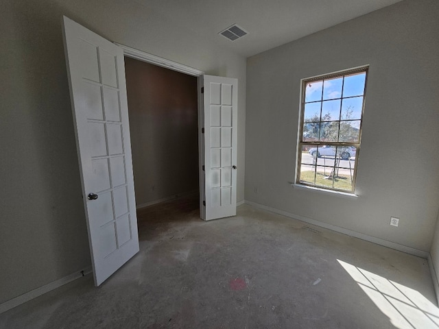 unfurnished bedroom with concrete floors