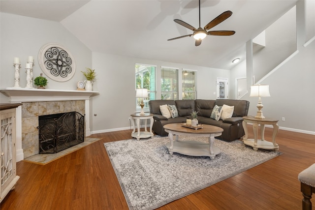 living room featuring a tiled fireplace, ceiling fan, wood-type flooring, and lofted ceiling