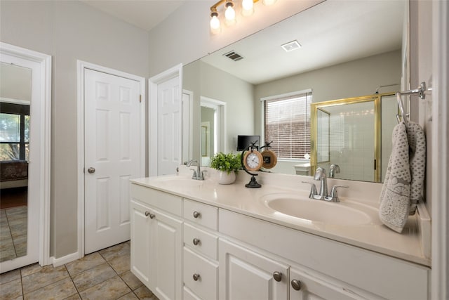 bathroom featuring tile patterned floors, vanity, and a shower with shower door