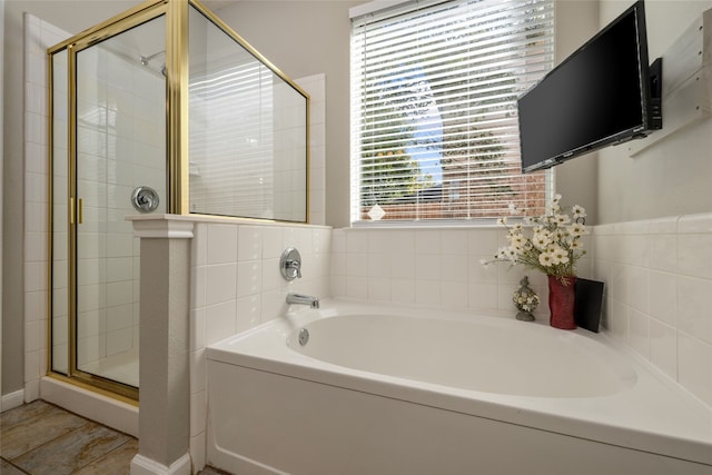 bathroom with shower with separate bathtub and plenty of natural light