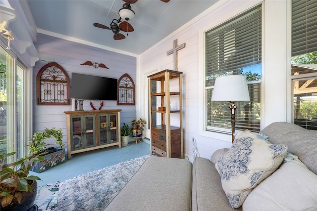 interior space featuring ceiling fan and wooden walls